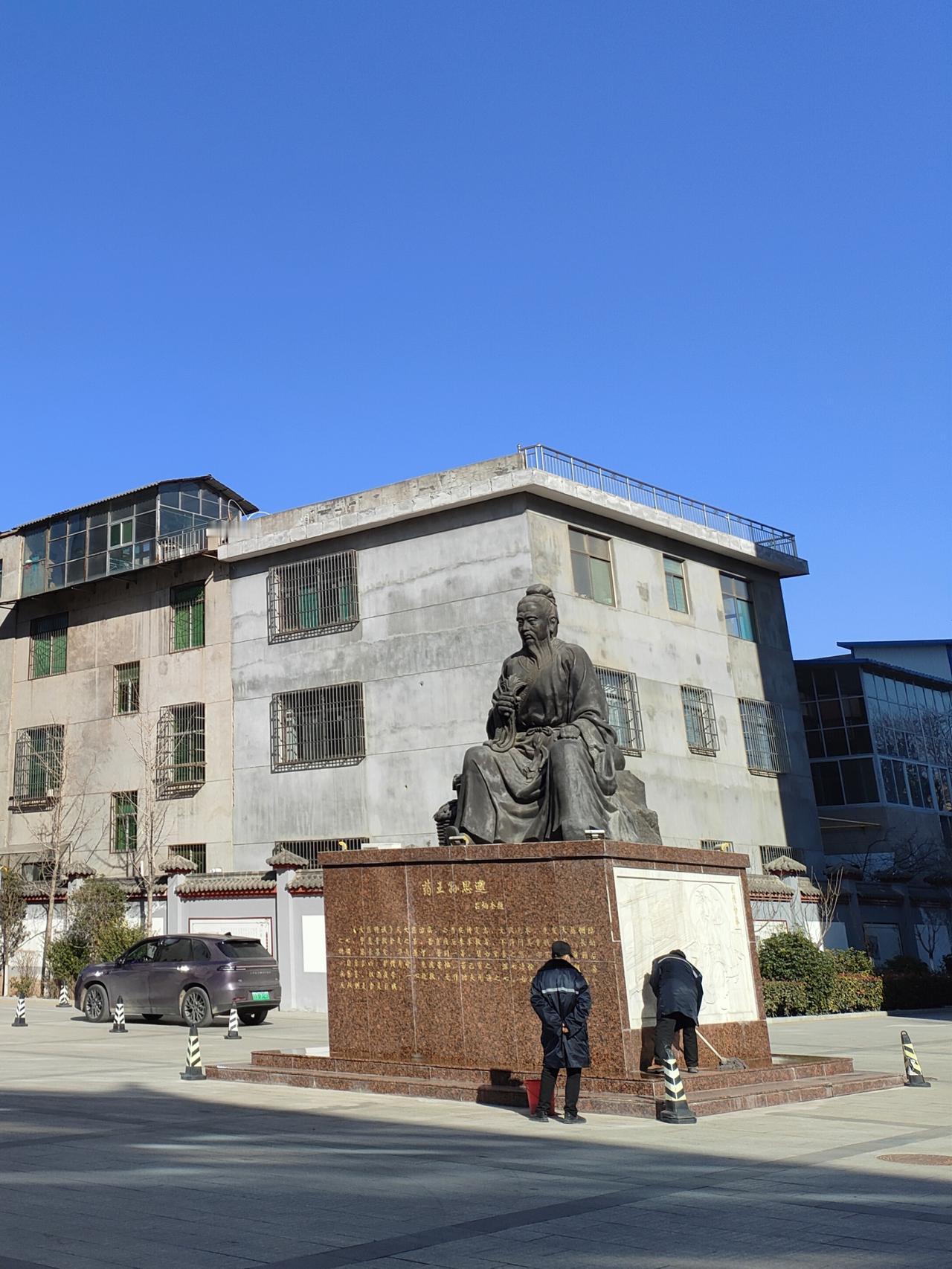 铜像在晴蓝底色里缄默，有人擦拭基座的刹那，光阴便从古老的衣褶，淌进了现世的尘埃。