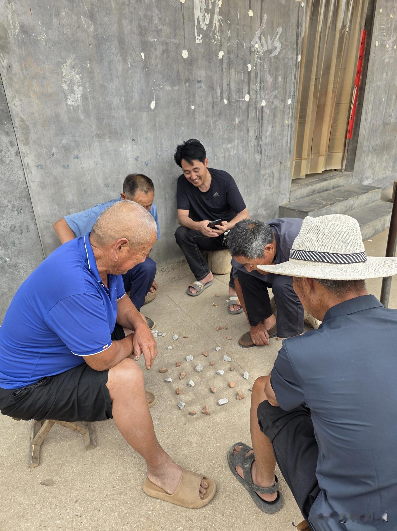 看看农村老人，娱乐方式有多么原始、多么简单……

在地上画一个棋盘，两种不同颜色