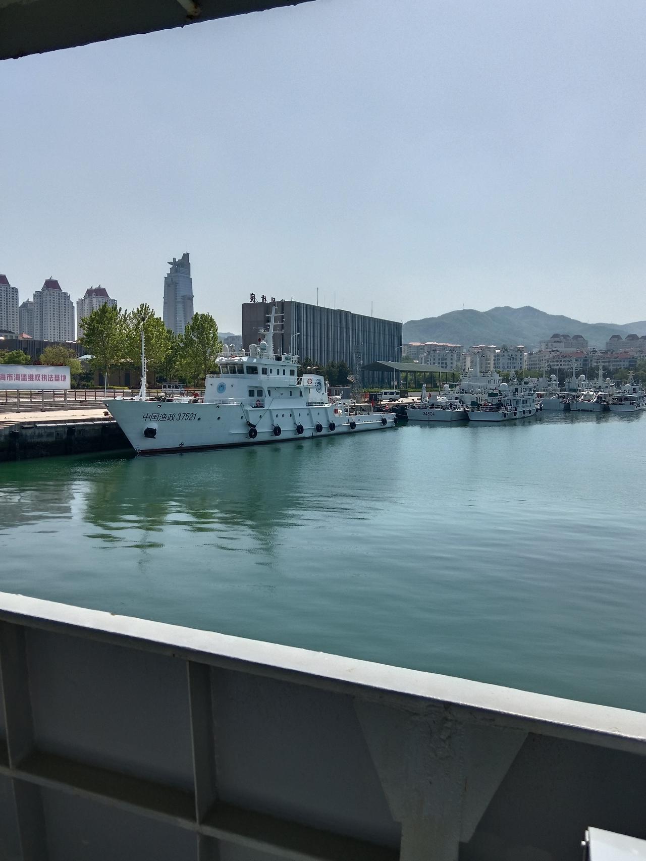 威海海监渔政执法基地，港湾里整齐停泊着多艘执法船只，显眼的中国渔政37521静静