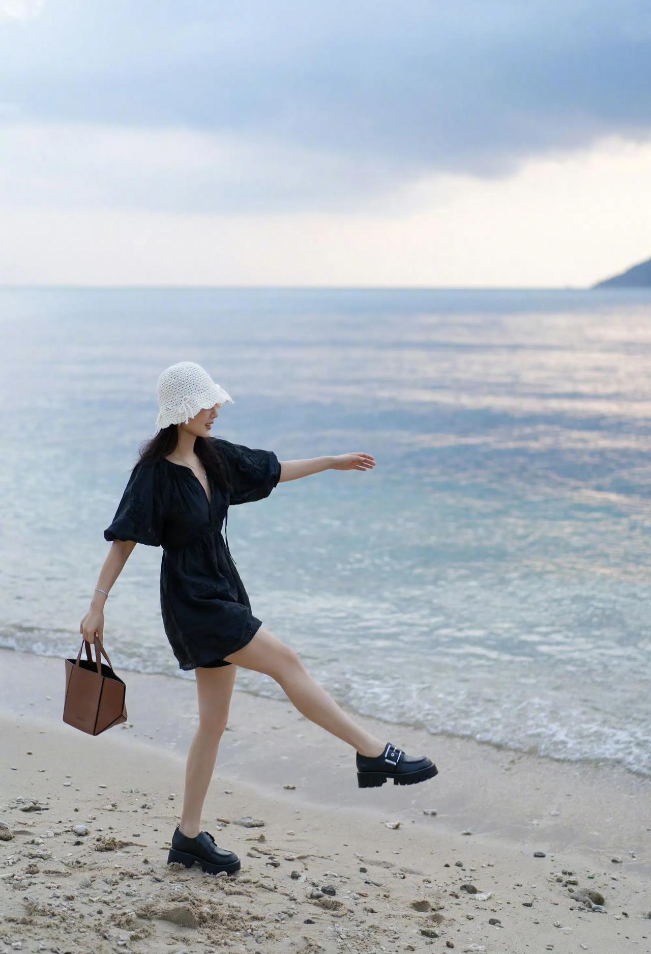 秋日的午后，她一身休闲装的打扮，悠闲的走在软绵绵的沙滩上。远处淡蓝色的海水，脚下