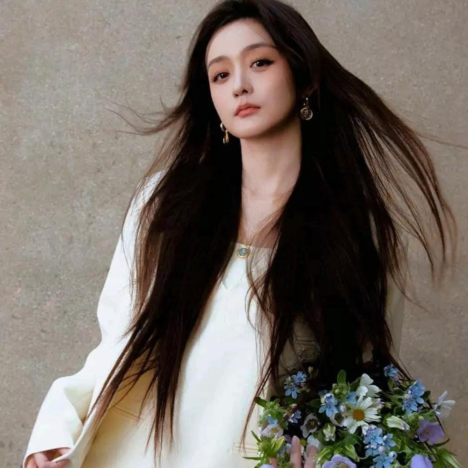 温柔飘逸的白色长裙，配上清新的蓝色花束，散发着优雅与自然的气息。白色女士长裙 水