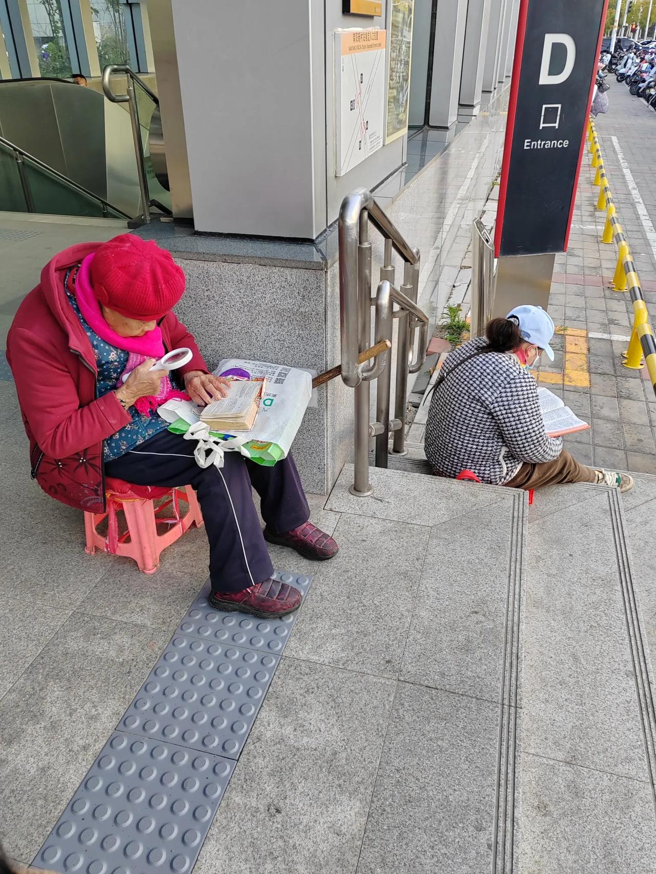 老铁们，是什么书籍这么有魔力，让九旬老太坐在地铁口、拿着放大镜也要坚持读下去……