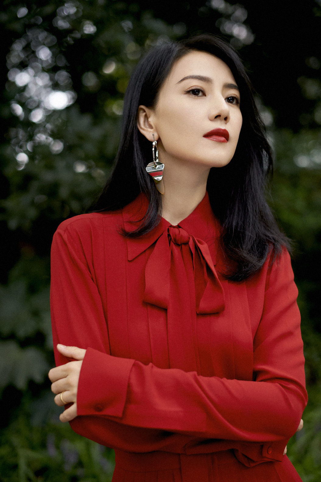 这身红装造型气场拉满，正红色系衬得肌肤莹白，领口飘带增添柔美感，搭配几何耳饰更显