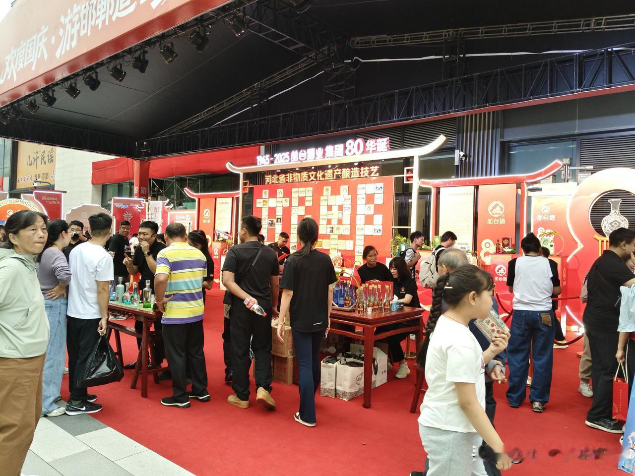 人们在展会上忙着品酒聊天。