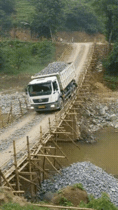 看着很危险，其实一点儿也不安全。这么重的重卡满载走竹子搭的桥，真是有点太离谱了！