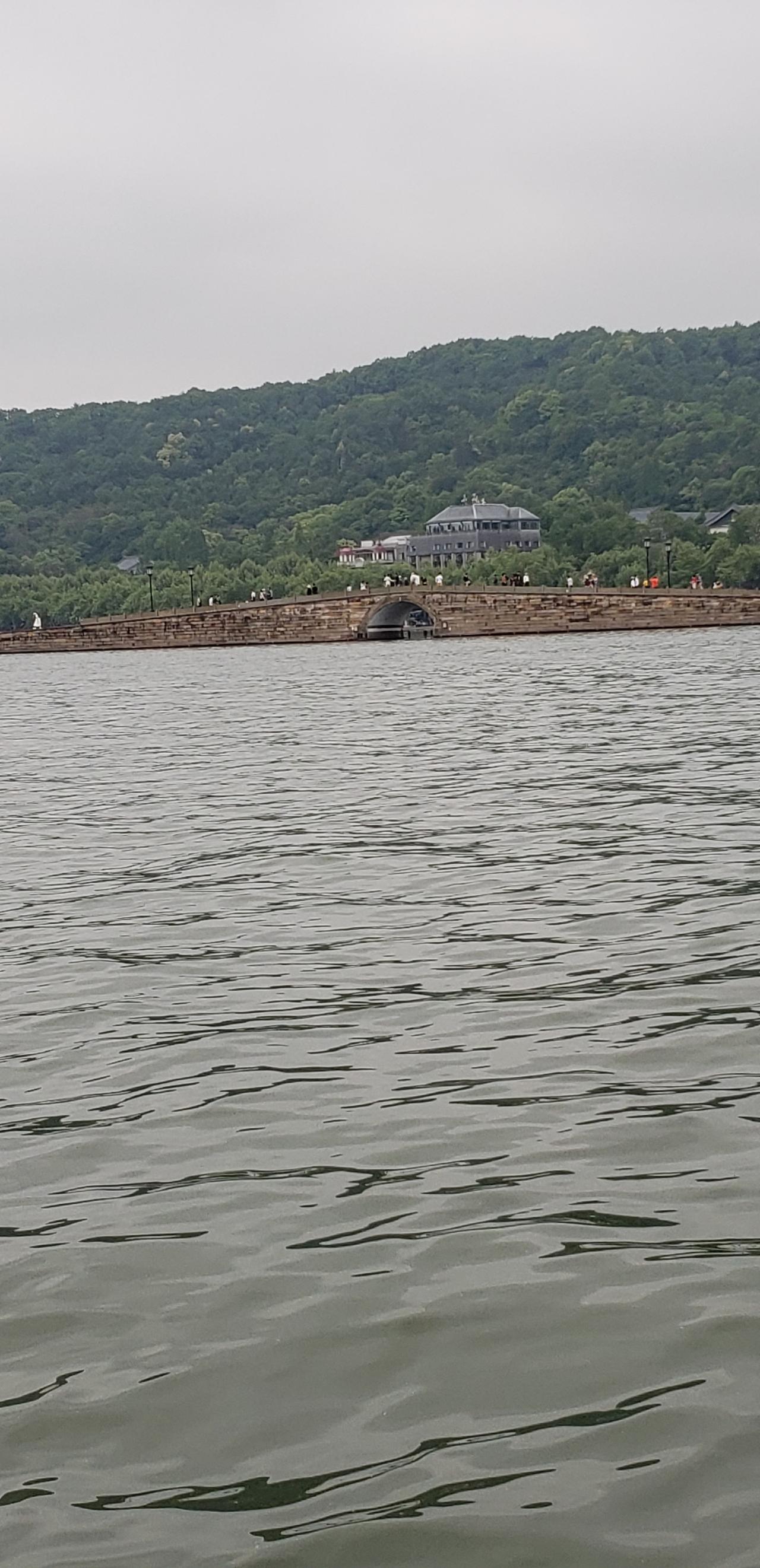 站在这里，脚下是许仙与白娘子的相遇之地，眼前是垂柳轻拂的西湖碧波。游船缓缓划过，