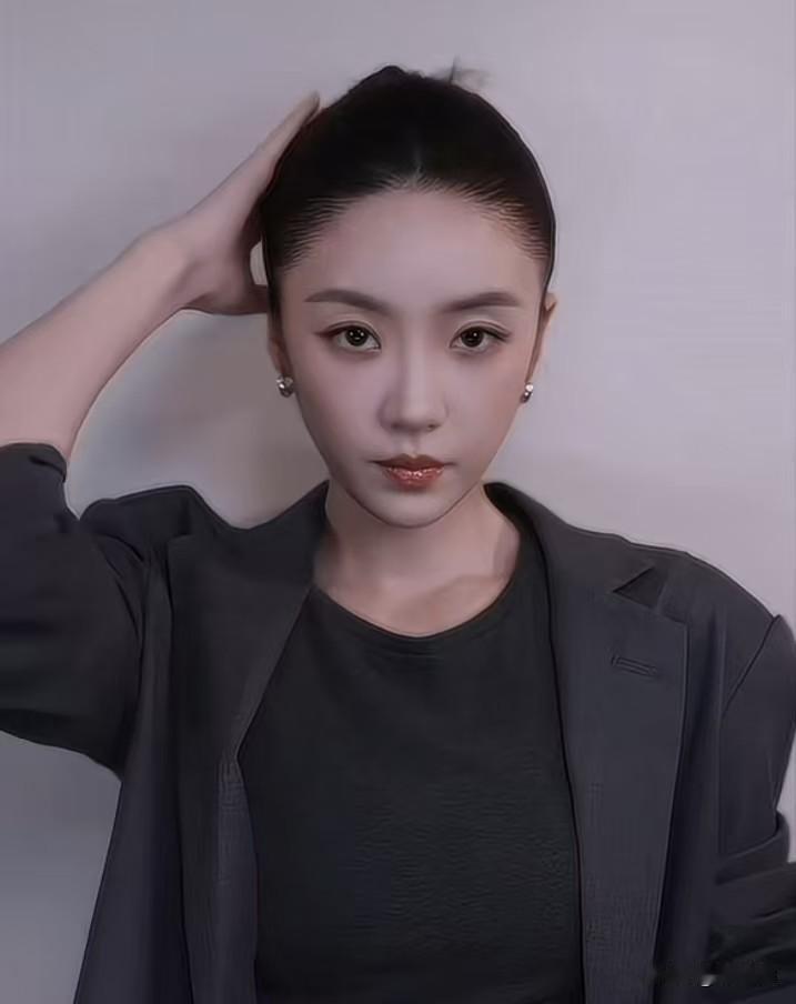 一丝不苟的利落发髻，一身简约黑色西装，清冷妆容衬得气场十足，干练又自带独特韵味。