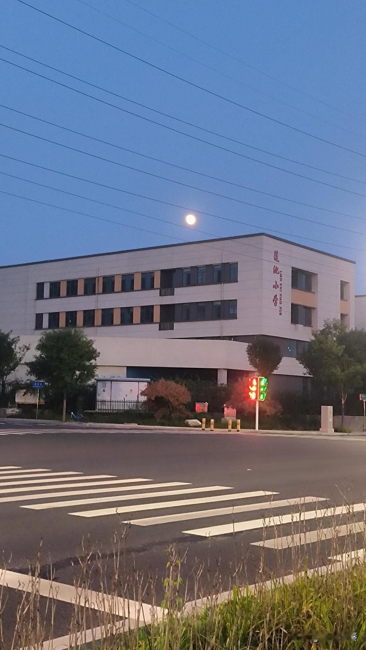保定锦湖南大街莲池小学，
骑行路上偶遇美景，
一轮明月静静悬在学堂上空。