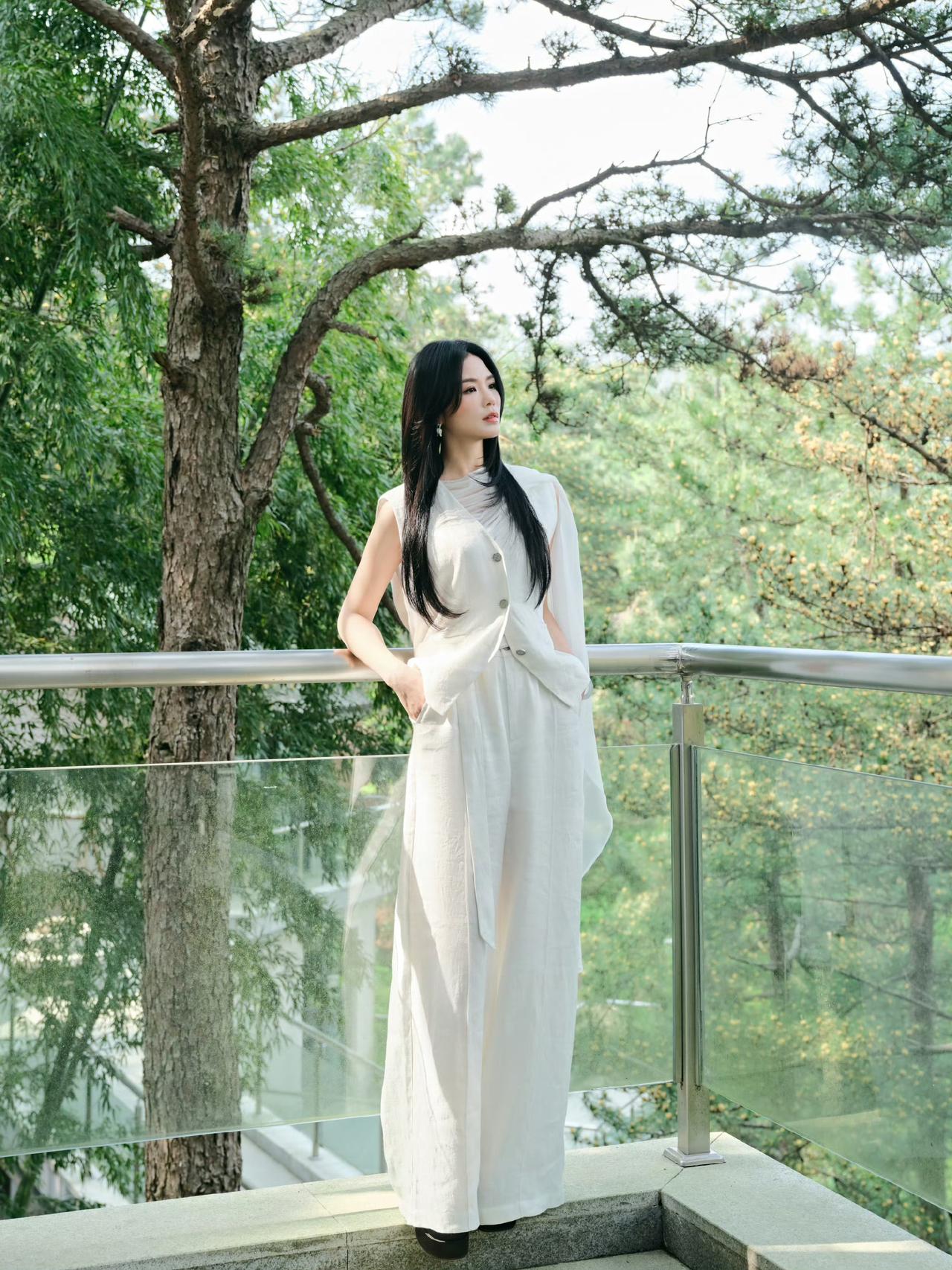 全白无袖套装+透视纱质披肩，宽松垂坠的版型衬得气质很松弛，极简色系搭配自然背景，