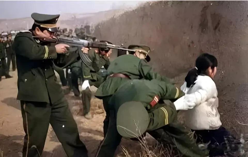1995年，正被执行死刑的女犯陆金凤，此时的她跪在地上，左右两名法警押着她的手臂