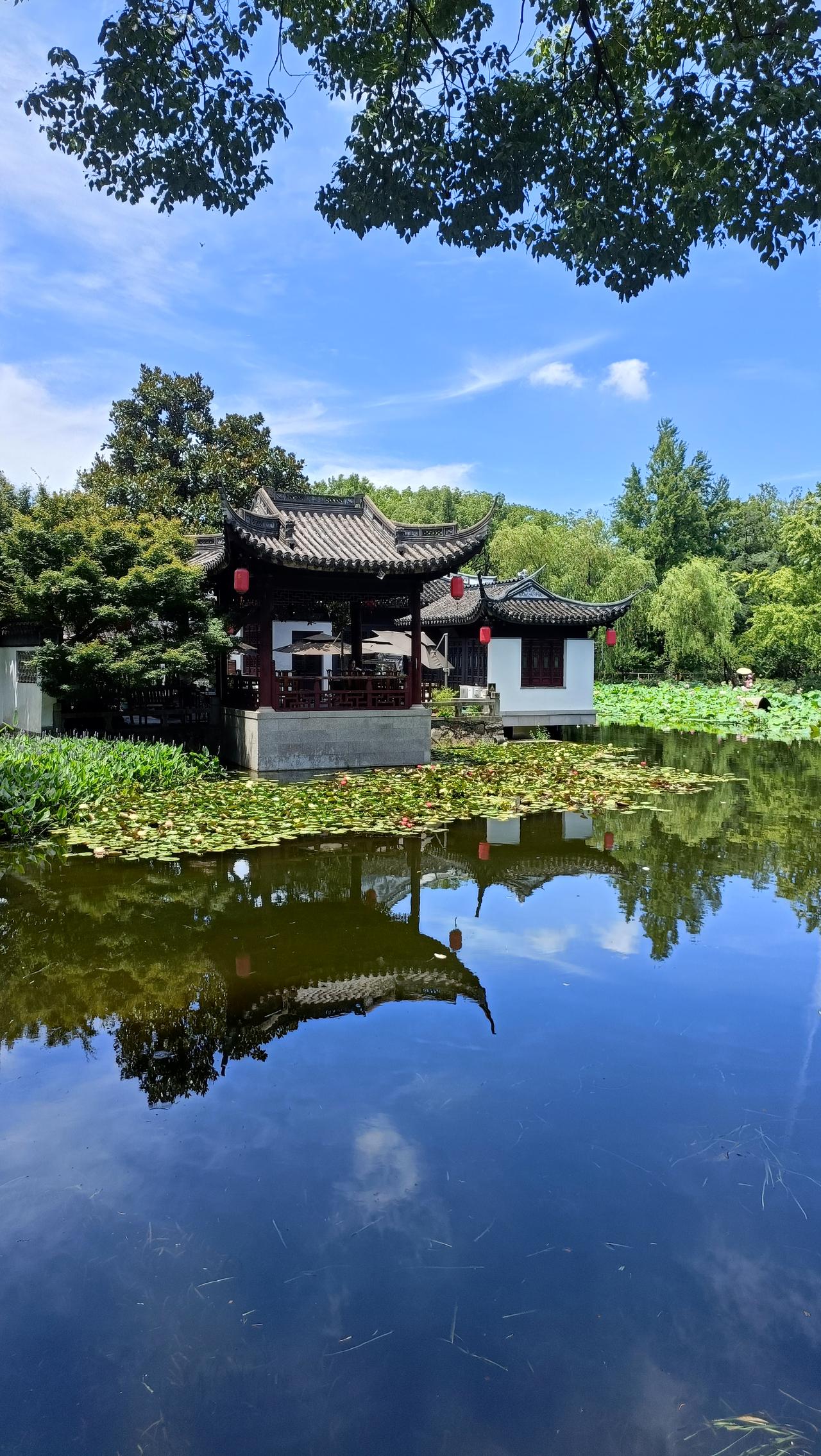 古风建筑倒映在静谧的湖水中，宛如一幅水墨画。
上联：静观湖光山色，
下联：心随波