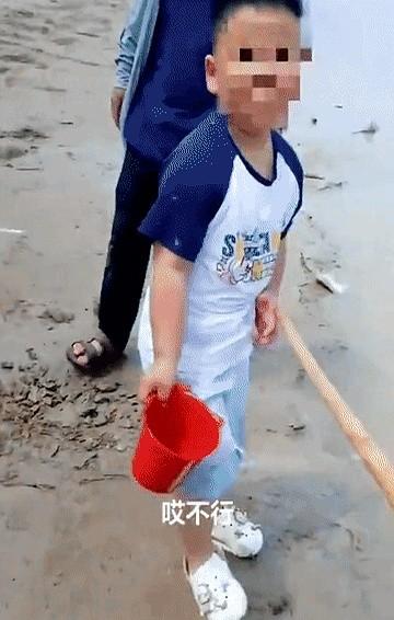 孩子河边玩命探头，老人放任不管，安全员赶忙拦阻。
安全员指着河水讲掉下去的后果，