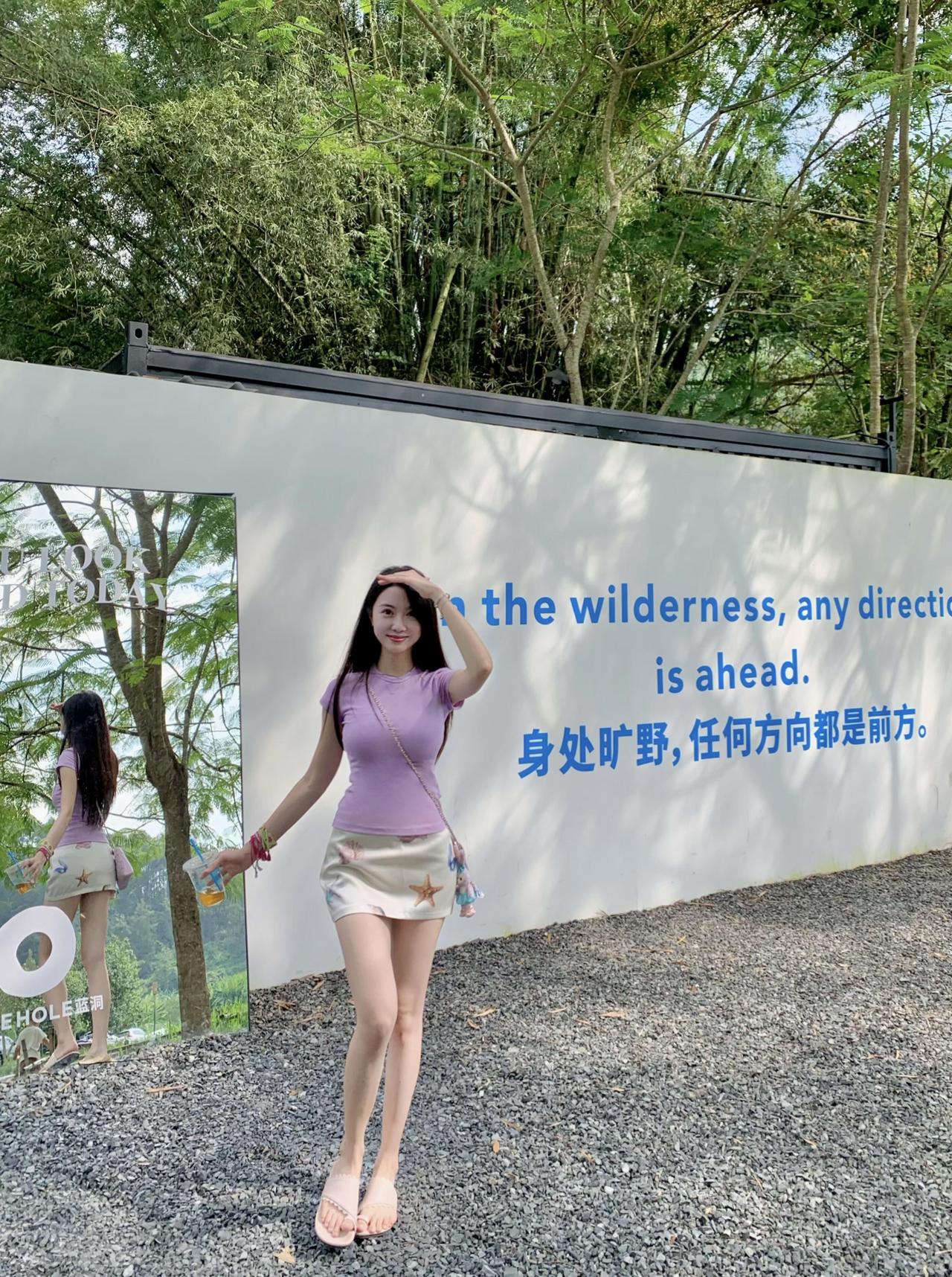 在这片绿意盎然的天地间，
她静坐，与自然对话无言。
瀑布轻吟，溪水潺，
绿荫下，