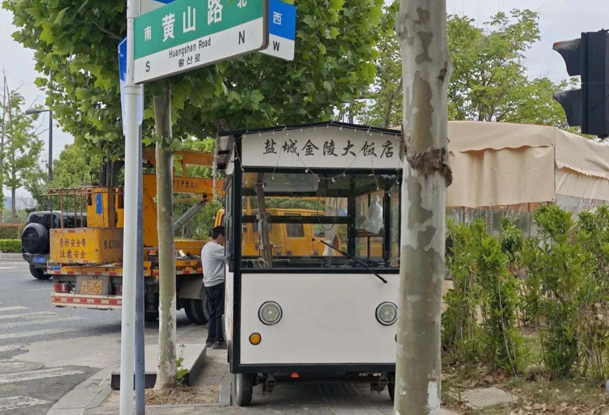 市民反映，盐城金陵大饭店在清溪路与黄山路交汇处设置外摆摊位，不仅擅自改动绿化带，