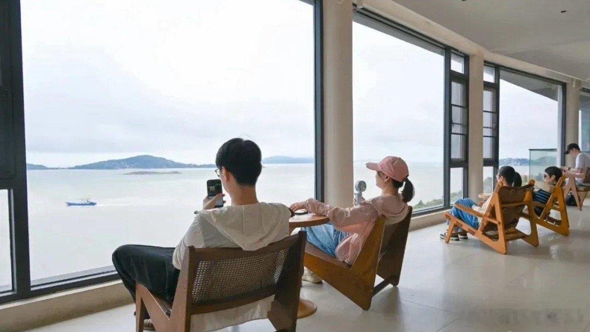 玉环悬崖书吧海咖慢时光主理人章金玲打造山海文旅驿站，夜晚灯光亮起，悬崖灯塔氛围感
