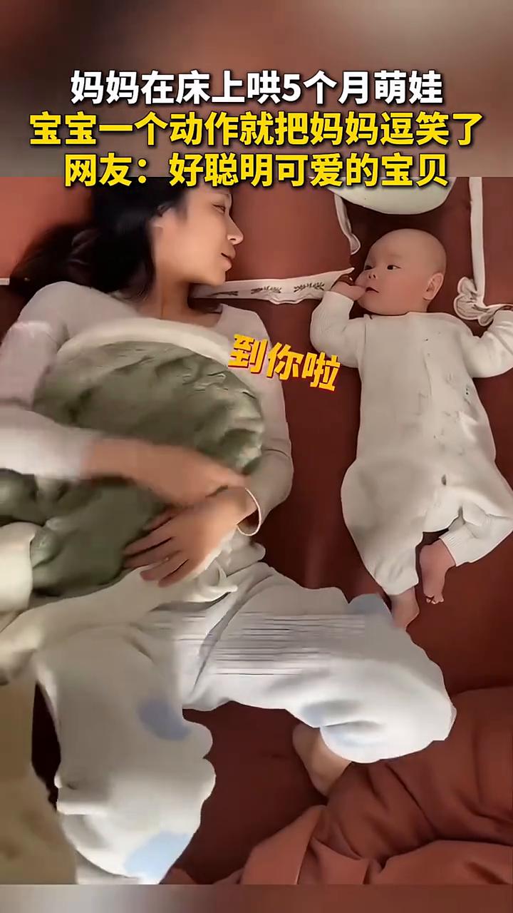妈妈在床上哄5个月萌娃，宝宝一个动作就把妈妈逗笑了。
网友：好聪明可爱的宝贝。一