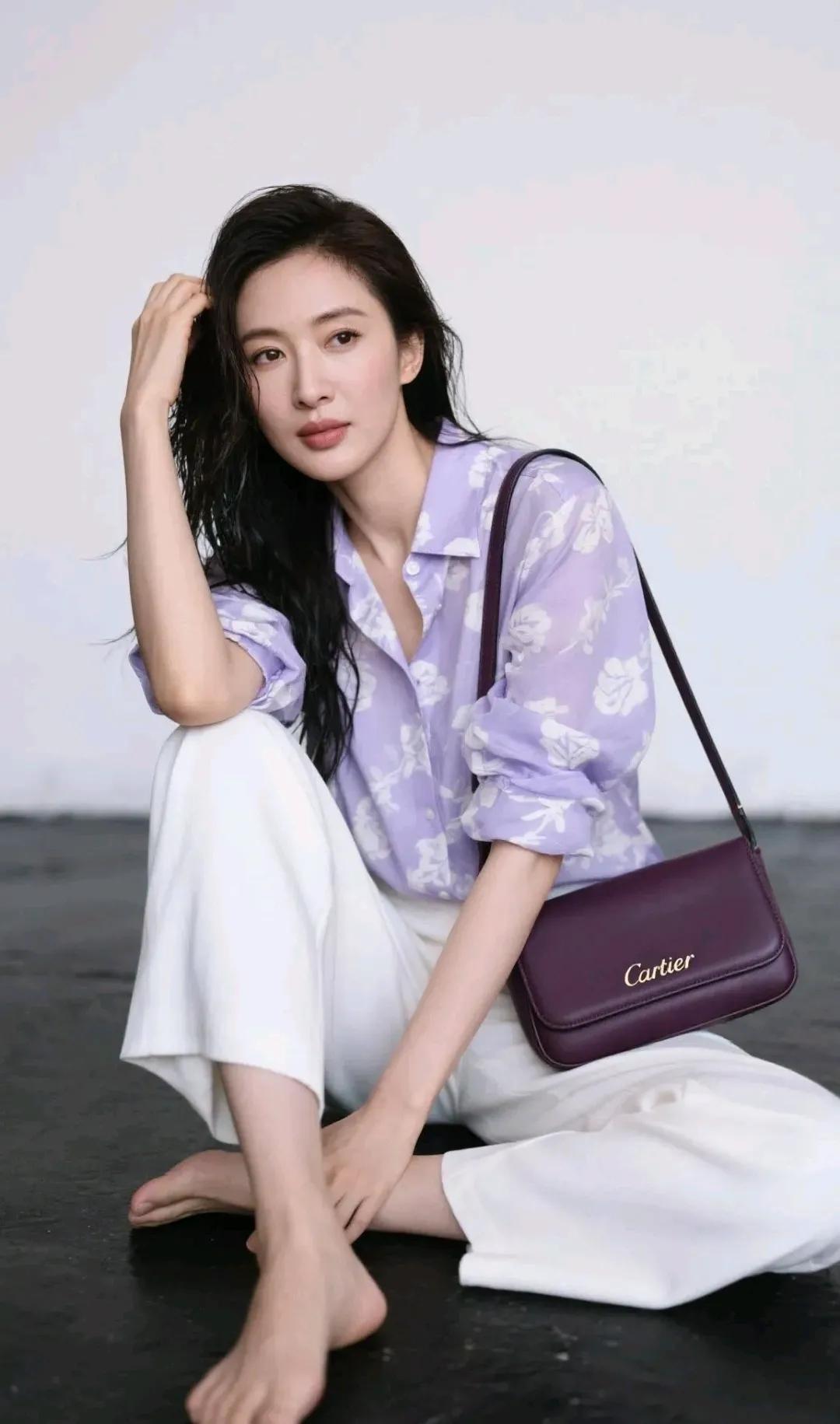 优雅气质，紫色花衬衫搭配白色长裤，手提Cartier包包，尽显时尚魅力。