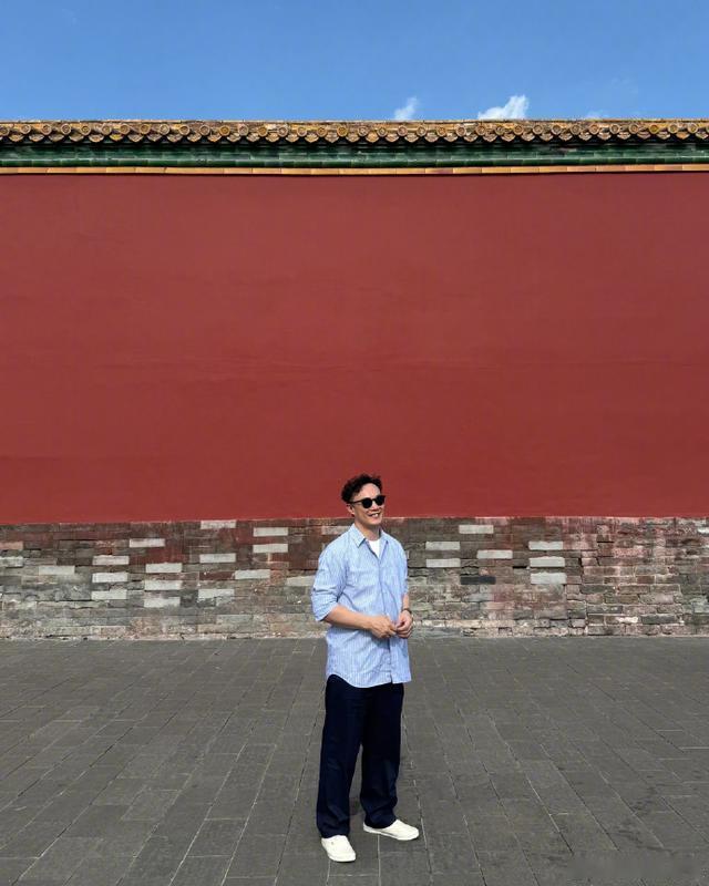陈奕迅在社交平台分享故宫打卡照，穿着与红墙相得益彰。古典与现代完美融合，展现独特