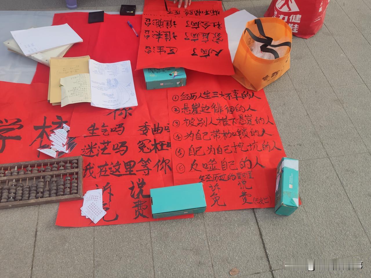 今天上午在郑州街头一路边公园里看到一位老先生在广场的一角铺了一个地摊儿，上面摆着