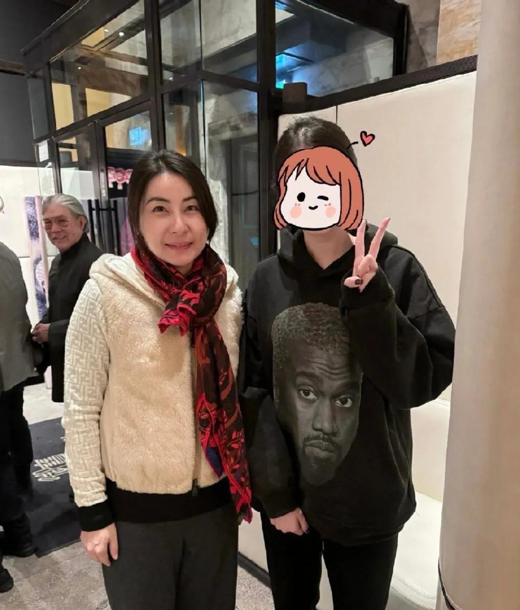 郭晶晶温和而又有礼貌地和网友合影，公公霍震霆一脸慈笑的看向儿媳和网友。