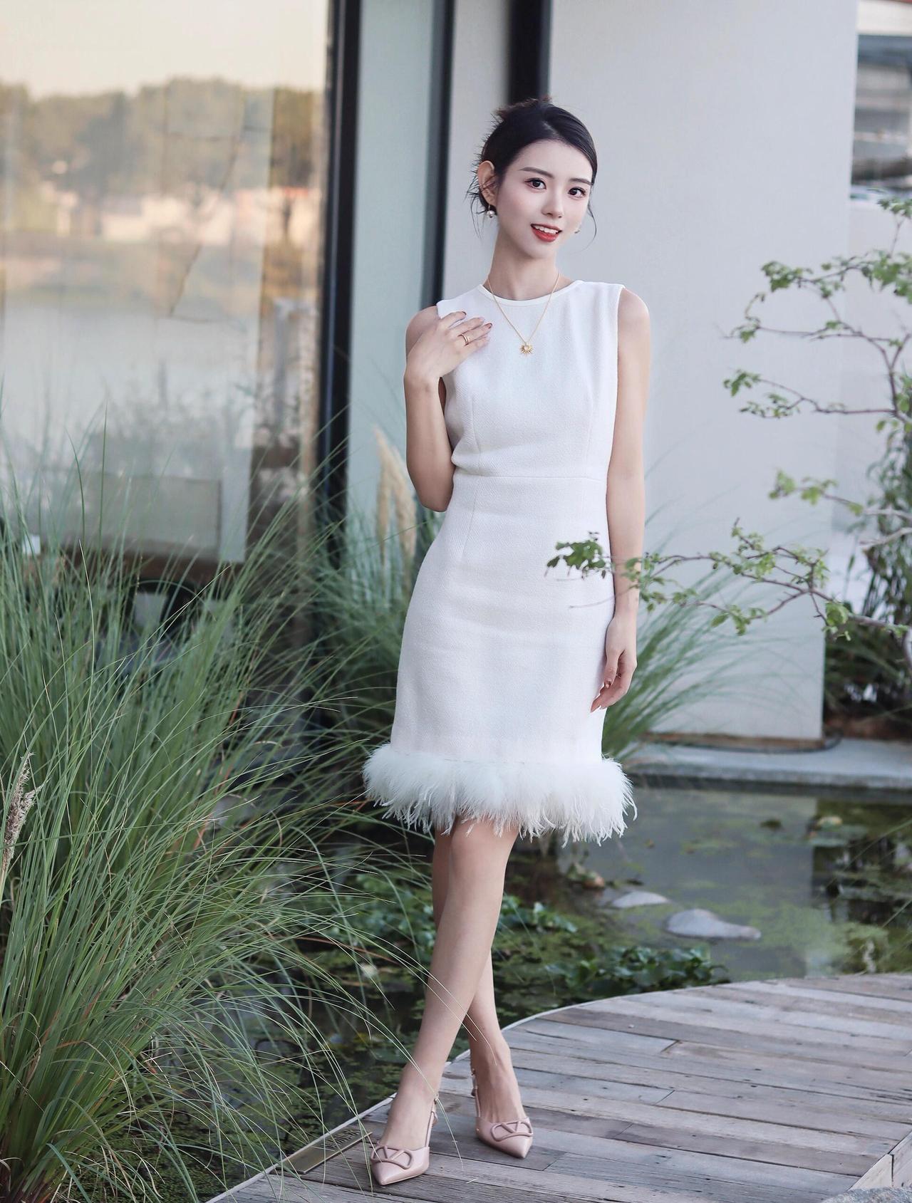 这套穿搭把“温柔精致”焊在身上啦~
无袖米白连衣裙自带优雅氛围，裙摆的羽毛边像裹