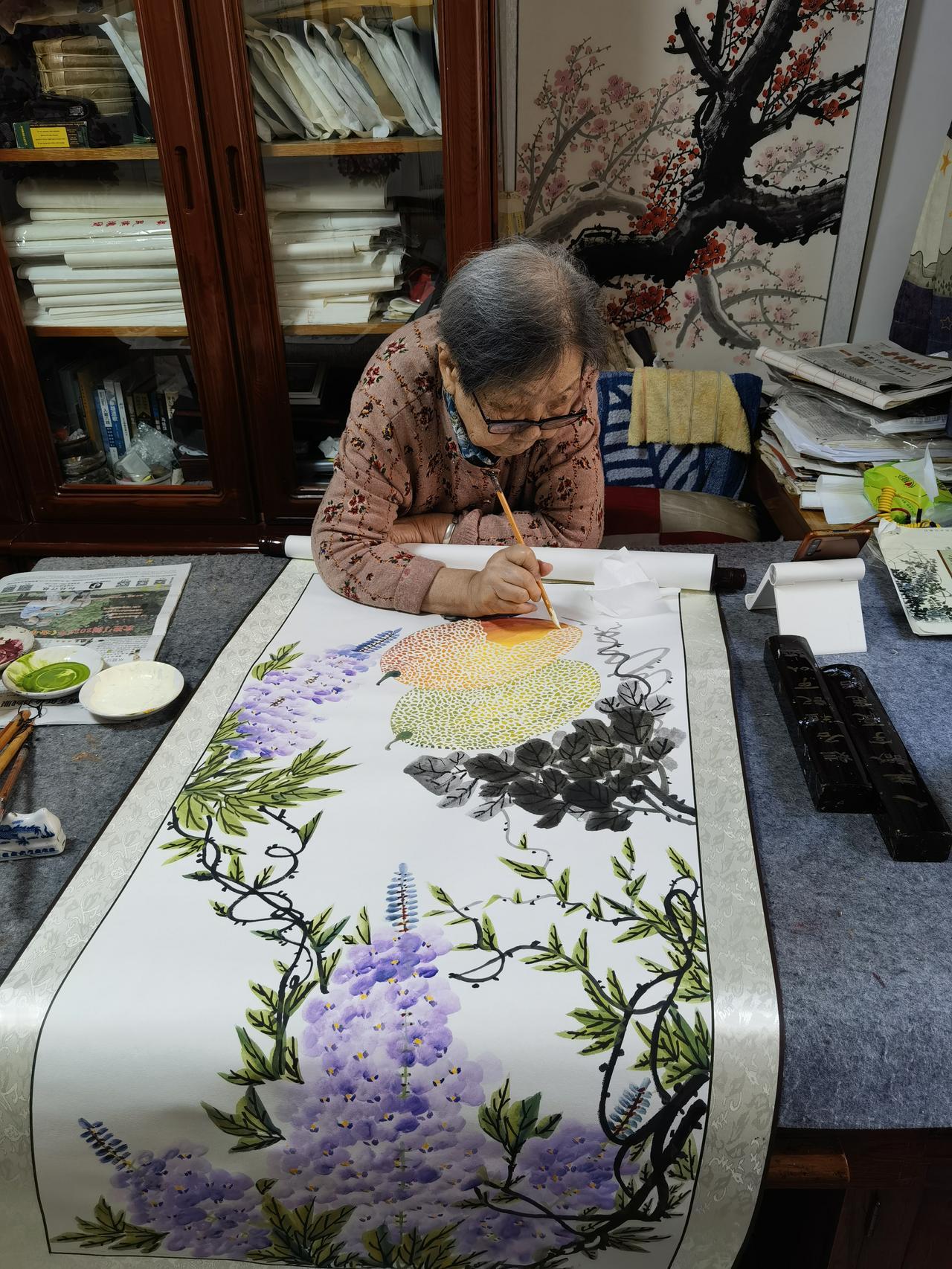 96岁的奶奶握着画笔，笔下的紫籐一串串垂着像要滴下水来；哈密瓜的橙黄果肉带着纹路