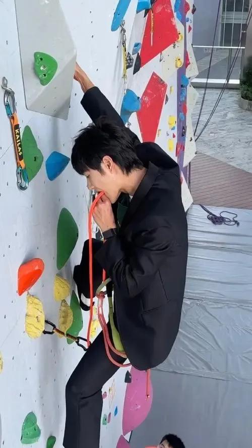 王一博挑战新高度，西装笔挺却身姿矫健，攀岩墙上展现非凡勇气与魅力，力与美的完美融