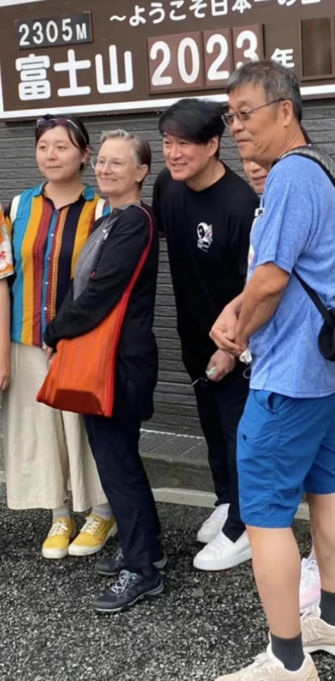 周华健和老婆日本游玩，穿黑色体恤搭配同色系休闲裤，脚踩白色休闲鞋，看起来显得十分