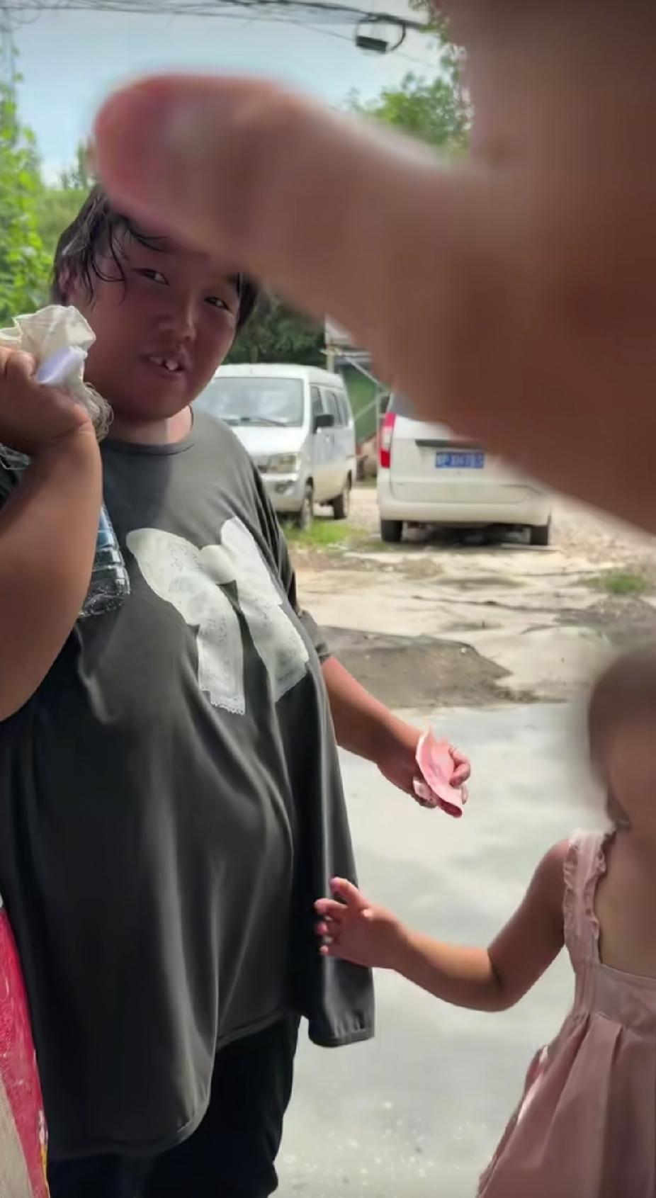 一位残疾妈妈，牵着孩子的手正在路边捡垃圾，路过的男子，做出的一个举动，让路人又惊