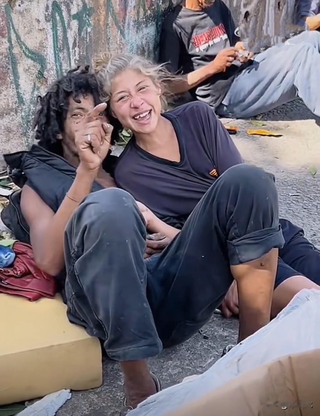 被斩杀线斩杀的一对美国年轻情侣，已经沦落到睡在大街上了，还可以对着镜头做出轻松和
