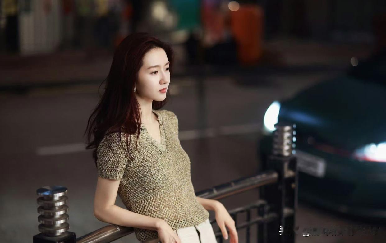 怎样穿搭能显示出温柔的女生气质? 都市夜景下的优雅女子，红唇轻启，夜色迷人。