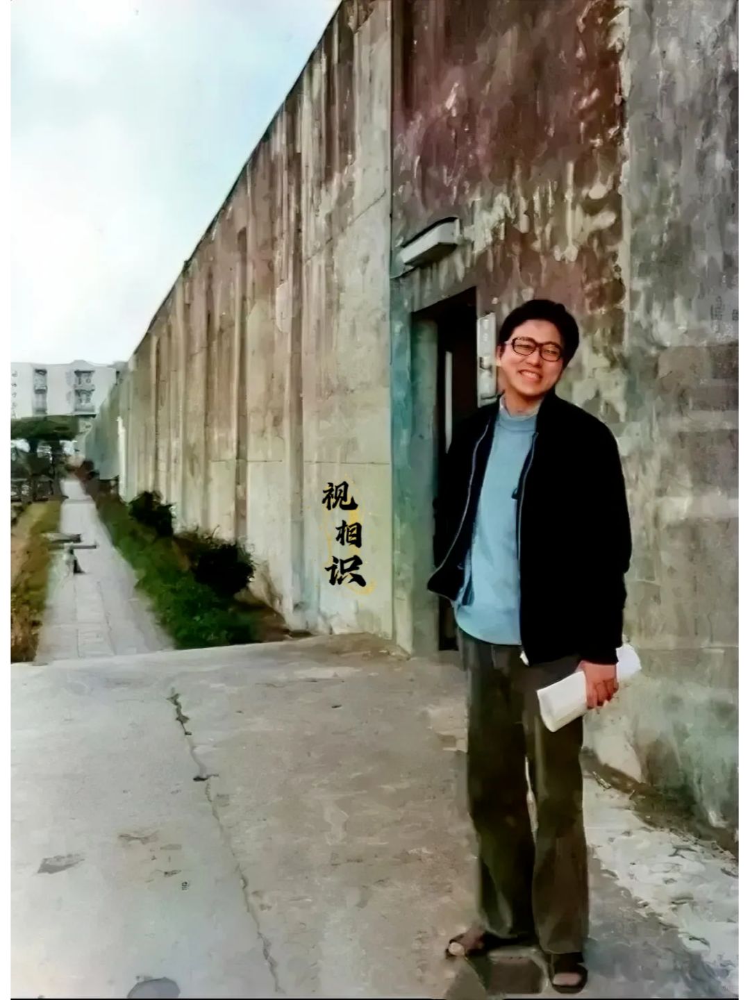 1976年，李敖刚刚出狱时留下的照片，镜头中他穿着拖鞋，蓝色上衣和黑色夹克，面对...