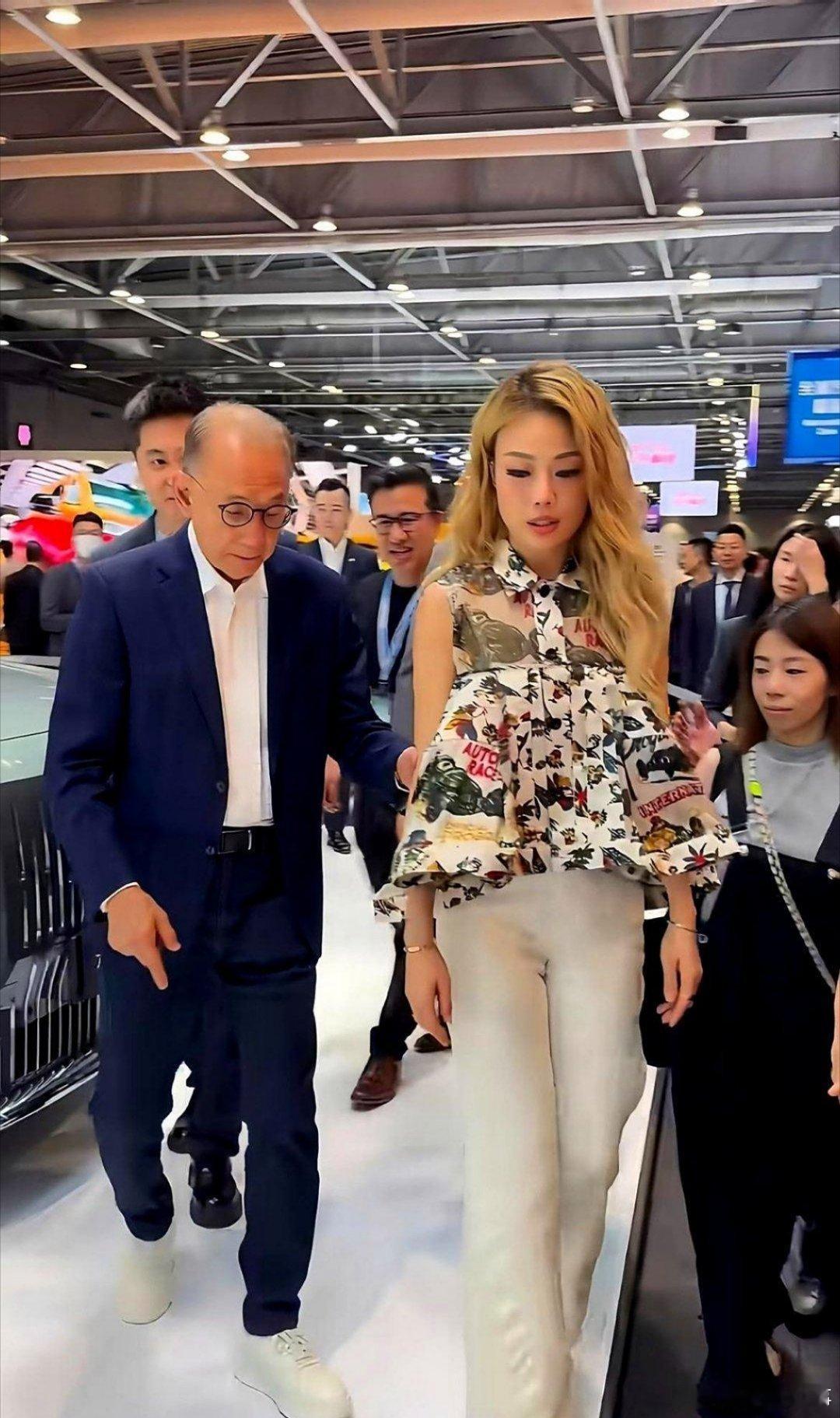 老板到死都不松手，图啥？车展镜头里，八十岁的杨受成拄拐站着，还伸手去牵容祖儿，被