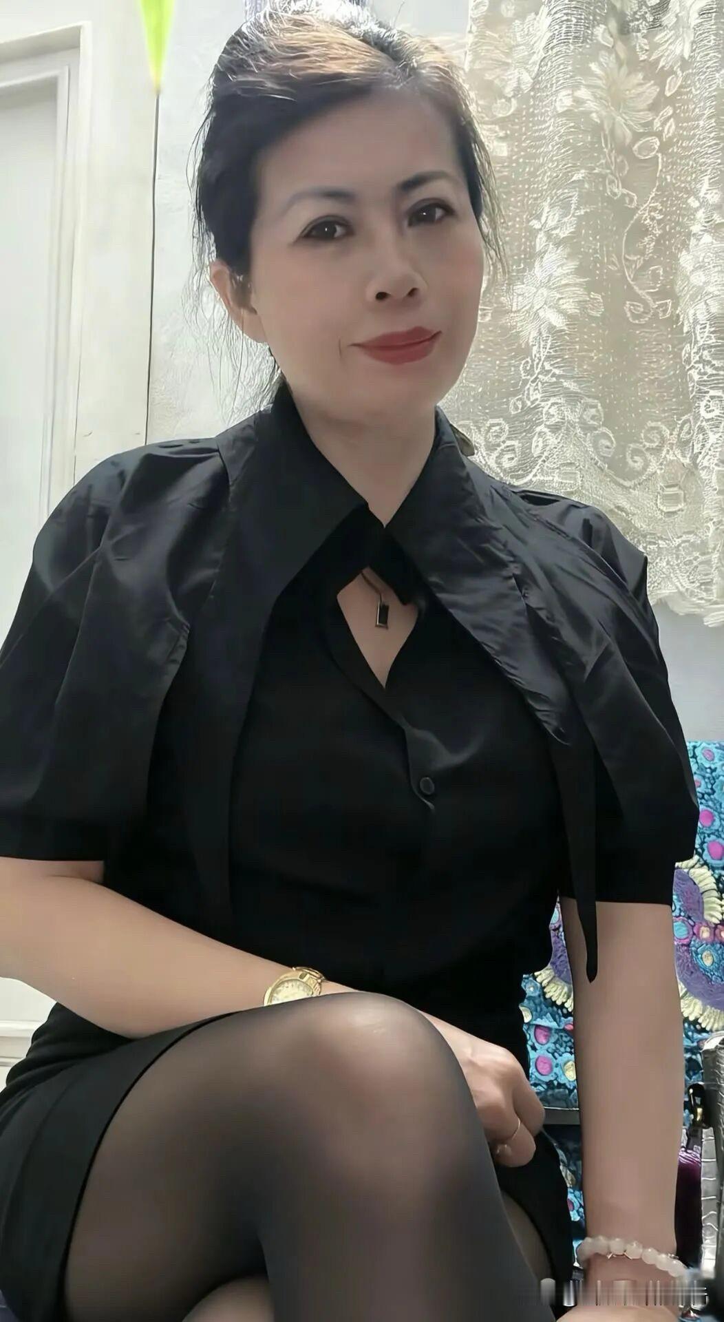 黑衫裁出利落的弧，金表与珠串私语，每个姿态都浸着从容的优雅。

蕾丝帘幕漫着柔，