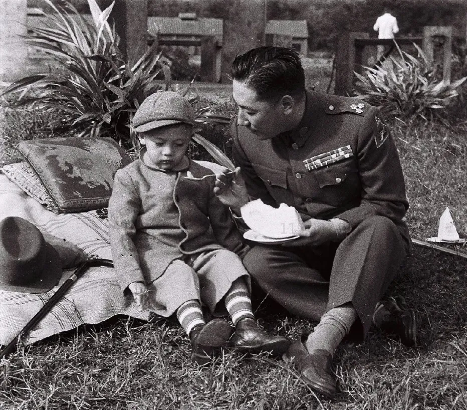 蒋纬国带侄子蒋孝武外出游玩时的一幕，他正在给蒋孝武喂点心。 
