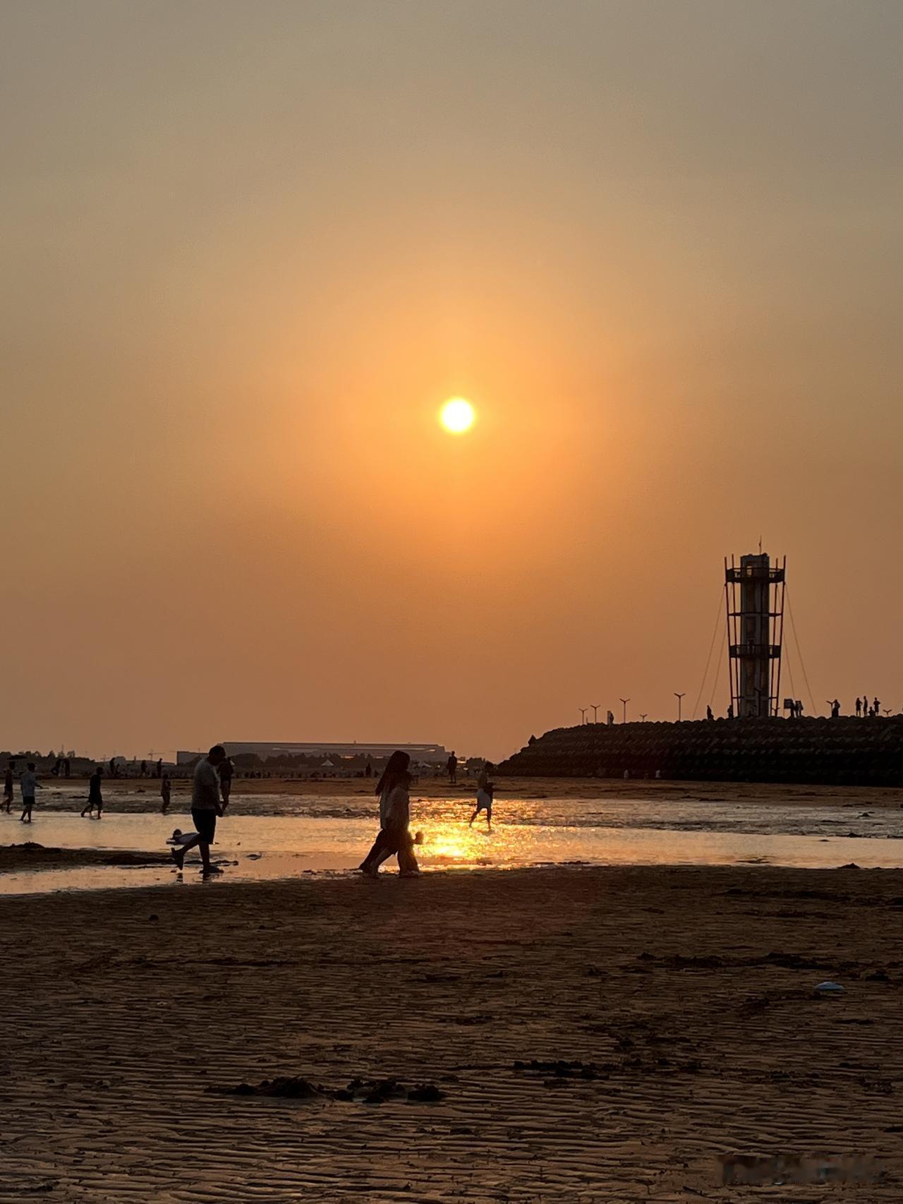 海风轻拂
细沙从指尖滑过
一抹霞光
悄然铺满天空的画卷
海浪翻涌
上演千变万化的