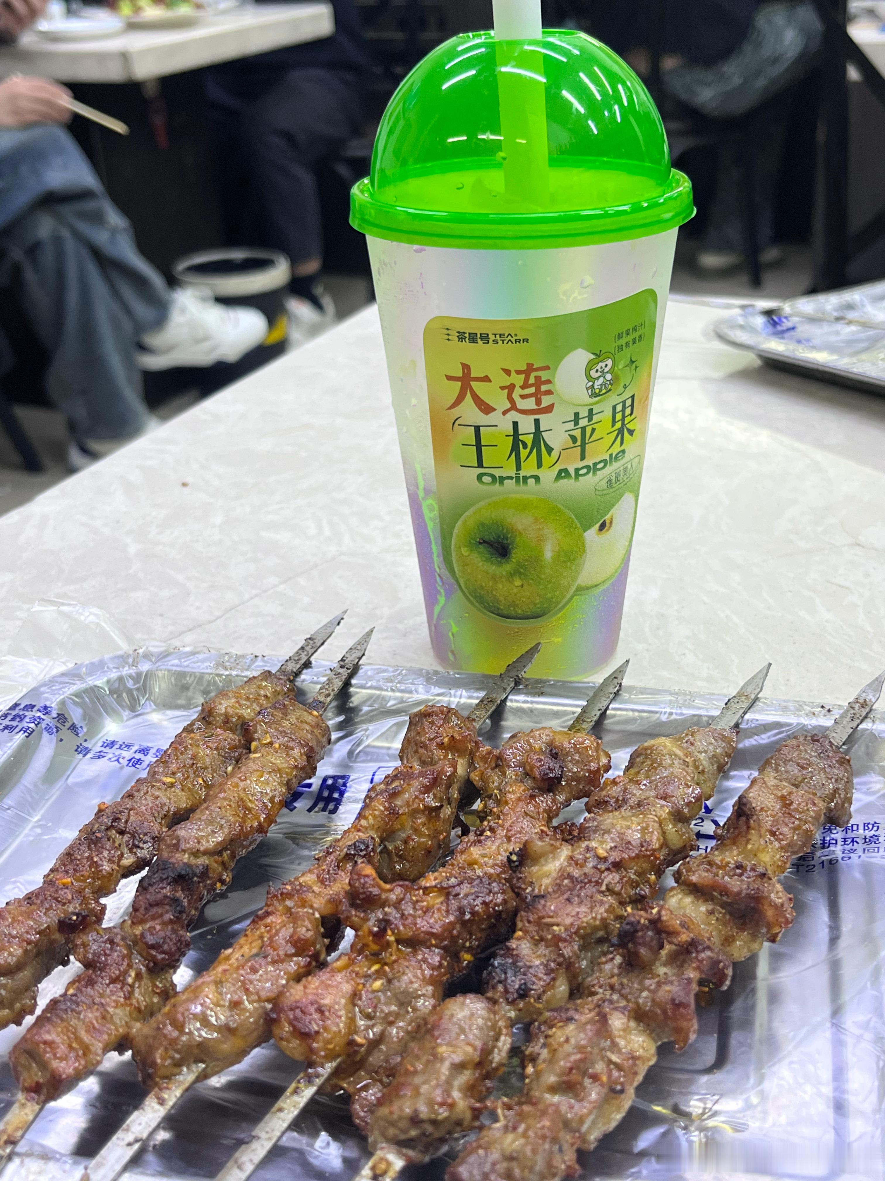酒店楼下就有一家烧烤小店，点了一杯玉林苹果冰沙配串儿，美滋滋大连的文体生活真的很