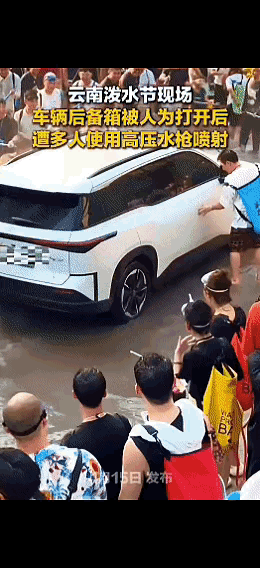 一辆私家车路过泼水节现场，个别人拉开副驾驶，后备厢车门，众人持水枪向车内喷水，这