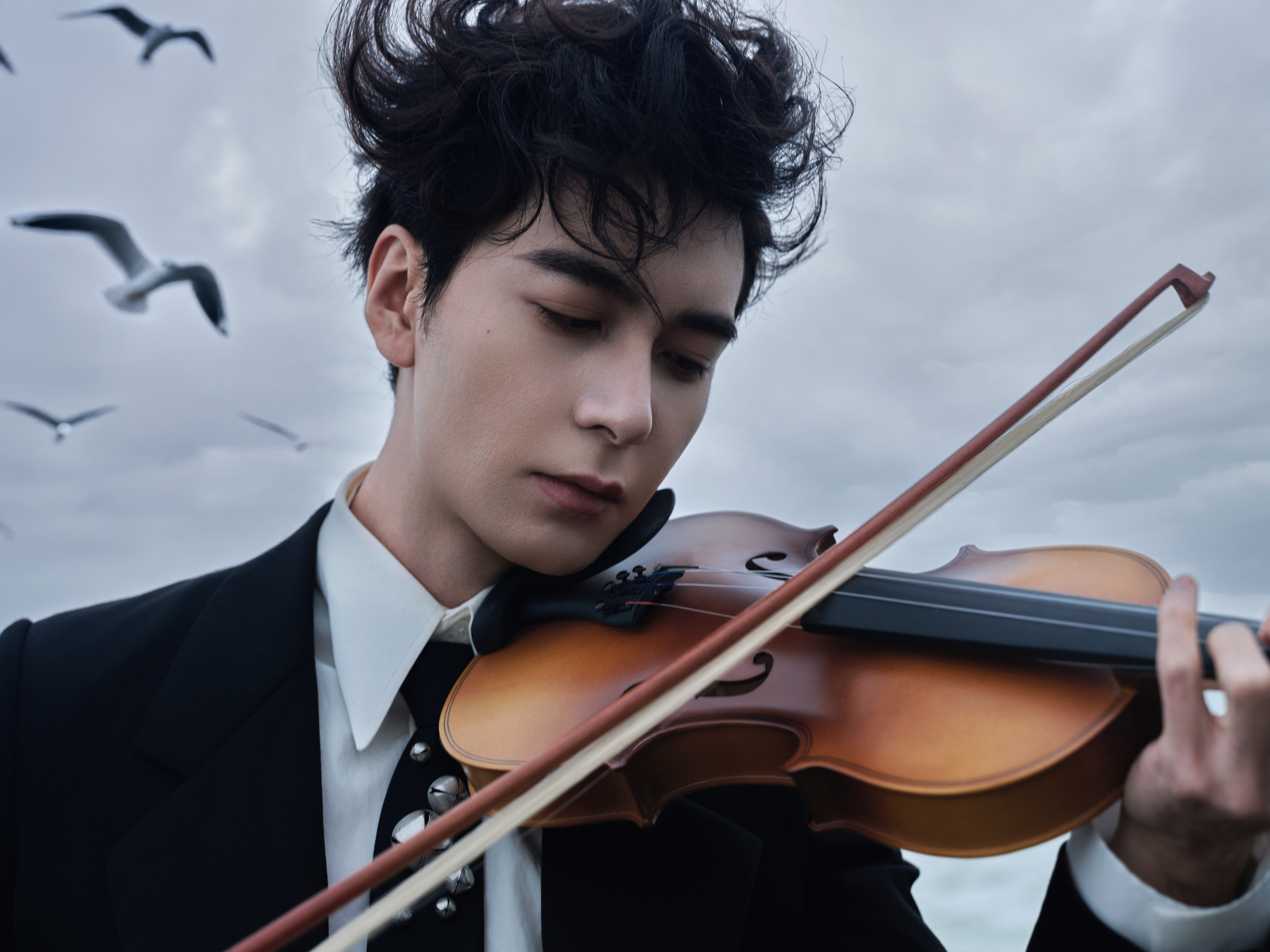 星光大赏出图   海岸的风揉乱他的发，墨色西装妥帖得像为这帧画面量身裁就——肩线