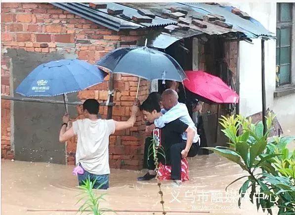 浙江义乌忽然下起特大暴雨，一位老奶奶带着小孙子出门办事，出门没看天气，随身就带了