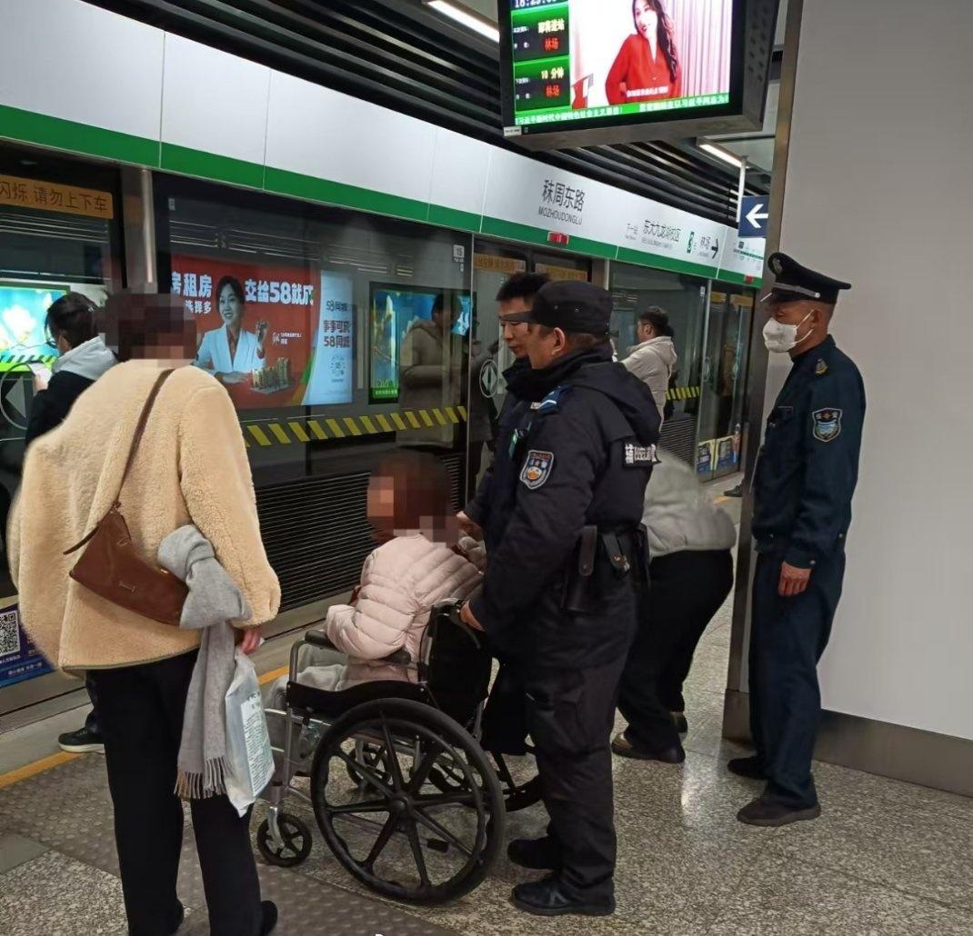 【脚下“失足”遇暖警 轮椅护送显温情】2月4日晚高峰，地铁秣周东路站执勤民警发现