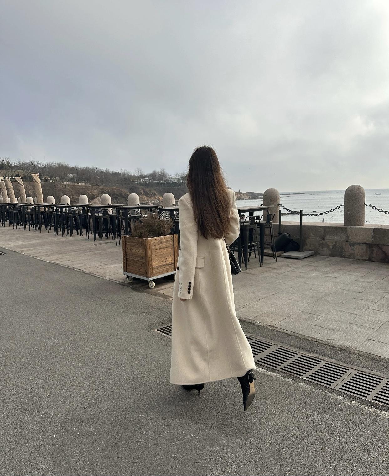 女生如何穿搭看起来时尚更有品味呢漫步海边，长风衣随步飘逸，感受海风拂面的自由与浪