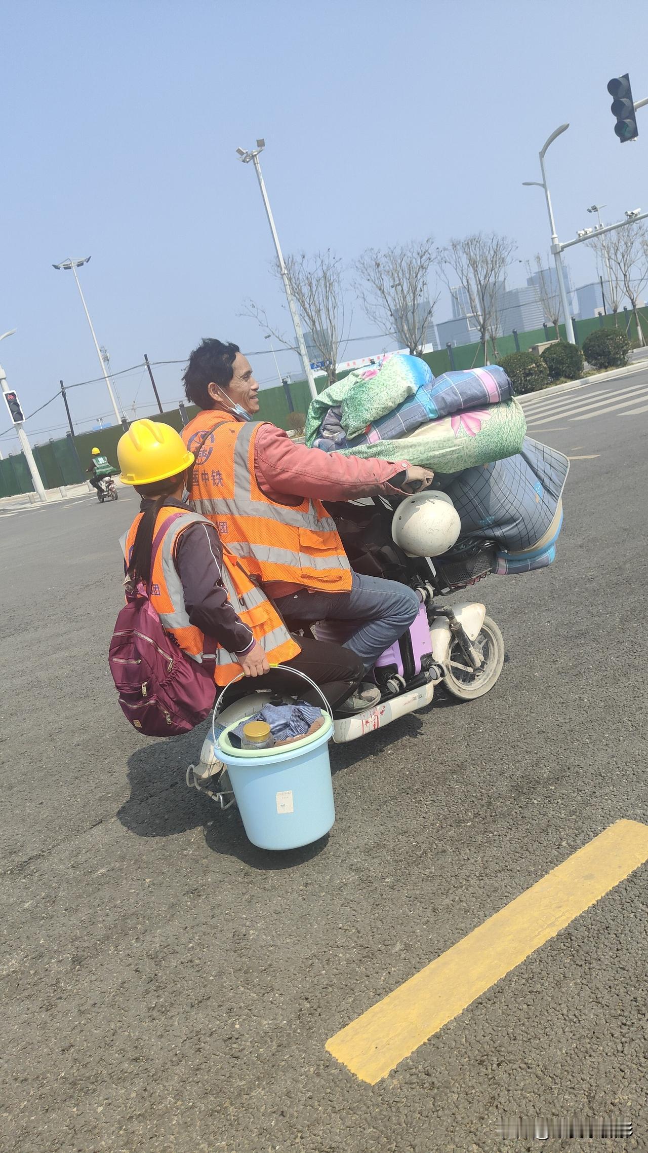 路过雄安新区启动区，路上看到这样一个场景，两个人骑着一辆电动车，还带着被褥，包裹