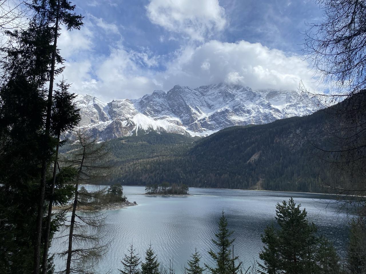 德国艾布湖的水面清澈见底，倒映着阿尔卑斯山的雪峰，岸边的小船像是悬浮在空中。阳光