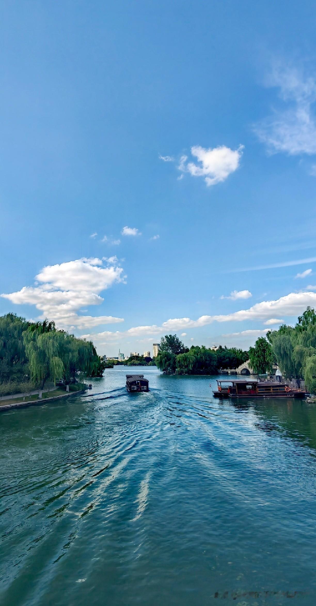 目睹蓝天白云之下，静谧河流上两艘船悠然前行的景象，恰似开启了通往世外桃源的大门。