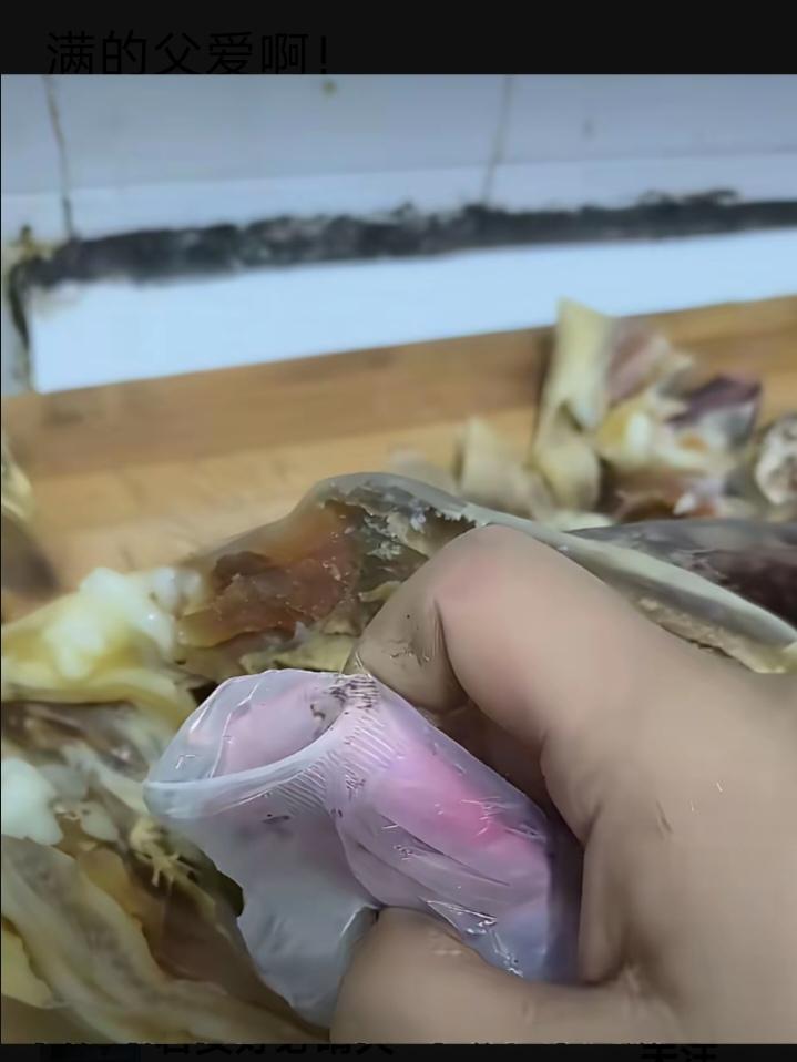 男子正在剁从老家带出来的腊肉，看到腊鸡肚里的一个东西，男子瞬间就泪目了。

男子