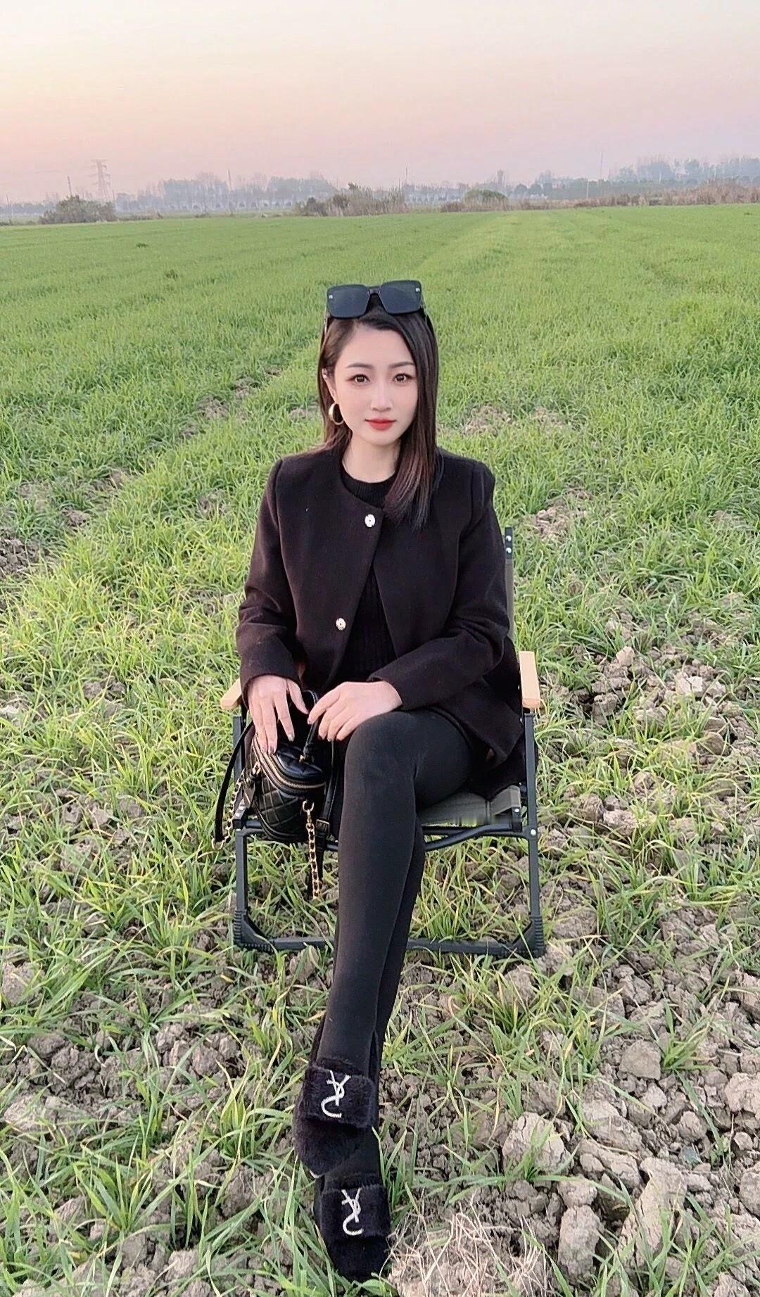 田野中的时尚少女，黑衣黑裤，优雅迷人。