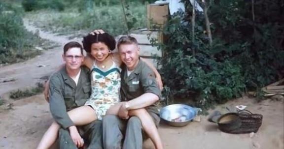 1952年，一名南朝鲜女子给两名美军做完服务后，当着老公的面热情地送大兵们离开。