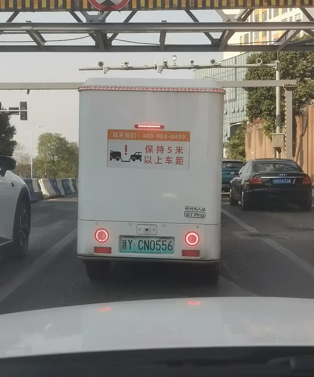 菜鸟无人车这两天在渝北回兴主路上慢悠悠晃，白壳子贴着菜鸟LOGO，没司机，头顶转