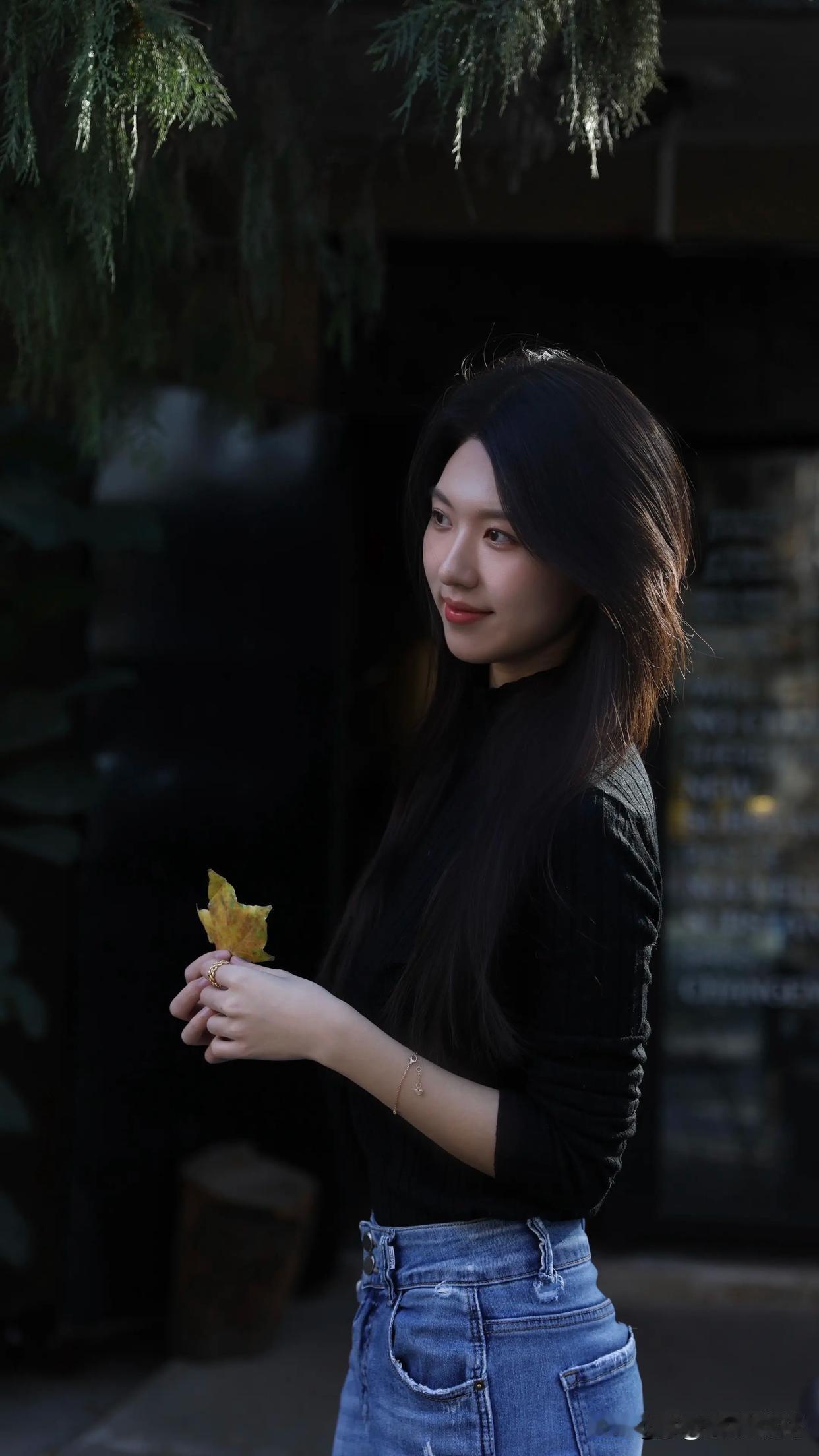 秋日暖阳，宛如一层金色薄纱，轻柔地洒在大地上。一位少女静静地站在树林中，伸出白皙